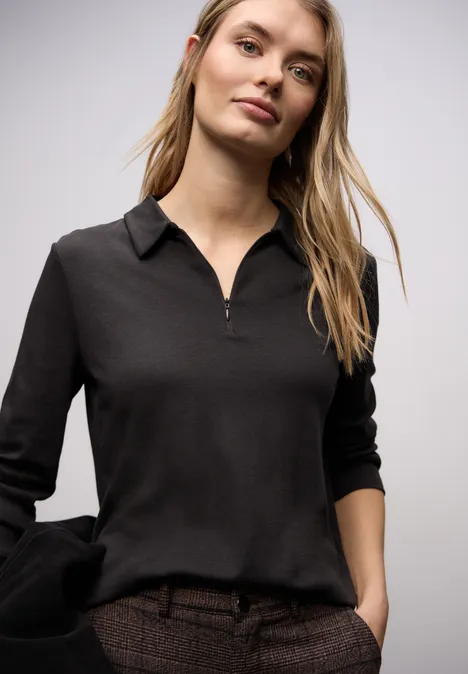 Schlichte schwarze Langarm-Polo-Bluse mit Reißverschluss, entspannt und modern geschnitten.